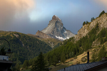 Hiking the trail of the majestic Matterhorn in the Swiss Alps, with its rugged, snowy peak towering above.