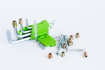 Metal hex key wrench set with bright green holder, screws and bolts, isolated on white.