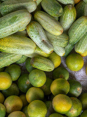 Fresh Cucumbers and Limes Displayed Side by Side at Market Stall