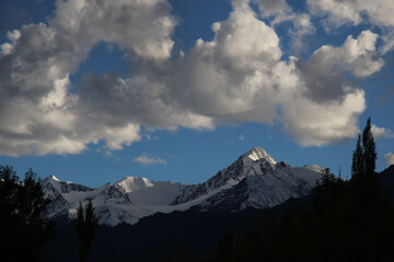 Dramatic clouds over snow capped peaks at sunset seen from Leh, India.