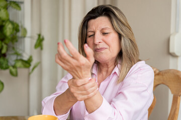 Senior woman feeling wrist pain, suffering from arthritis symptoms, experiencing discomfort, joint...
