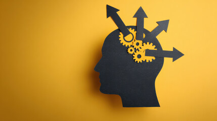 Silhouette of a human head with gears and arrows symbolizing thinking, innovation, and mental processes on a yellow background.
