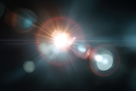 Abstract view of a brilliant light source bursting with energy and surrounded by lens flares