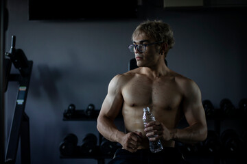 Athletic shirtless handsome young man, muscular young men are exercising with weights in a gym.
