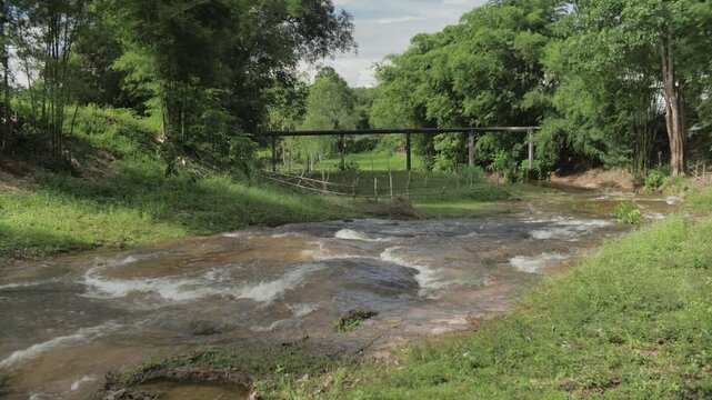 Scenic view of a small waterfall from a spillway dam surrounded by green nature at Huai Mu Ton, Sakon Nakhon, Thailand, perfect for travel and nature footage