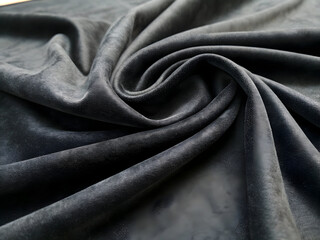 Fototapeta premium Dark gray velvet fabric texture background with soft, luxurious folds and rich swirling drapery.
