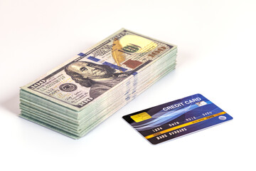 Stack of hundred dollar bill and credit card on white background showing financial comparison and decision making emotion
