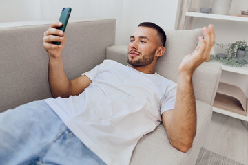 Thoughtful man engaging with his phone, reflecting on digital detox and mental health, embodying soft masculinity and emotional vulnerability in a serene environment.