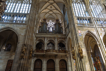 Interior view of a grand cathedral, featuring a pipe organ and elaborate stone arches, highlighting...