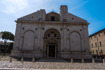 Obraz premium Grand church facade with arches, columns, and detailed stonework under a clear blue sky, showcasing classic architecture.