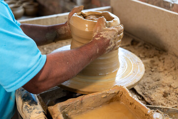 Close-up of the hands of a potter craftsman creating a clay vessel in the traditional way