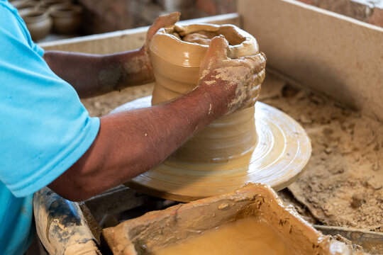 Close-up of the hands of a potter craftsman creating a clay vessel in the traditional way