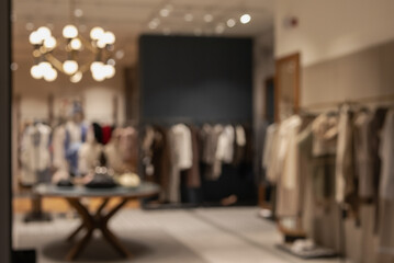 blurred background of a stylish, modern clothing boutique interior with racks of apparel, a...