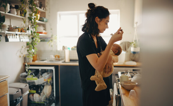 Mother holding infant in kitchen