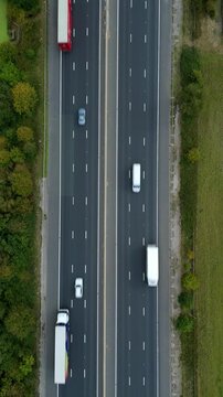 Drone aerial perspective of busy motorway highway with traffic, two lanes, England UK transportation of cars and goods by trucks, road infrastructure 