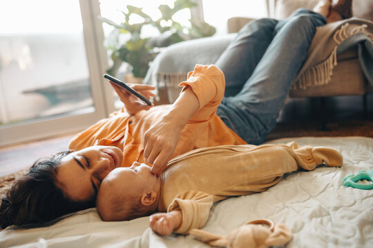 Mother and baby bonding at home with phone