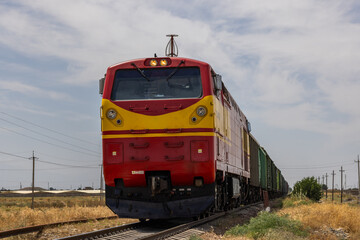 Freight train moving through serene rural landscape during daytime in Kyrgyzstan