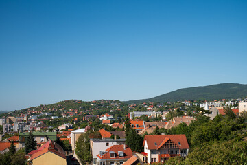 Obraz premium Panoramic view of suburban rooftops and green hills 