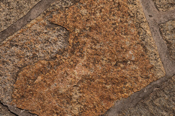 Natural stone pavement with irregular brown tiles
