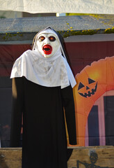 Spooky Halloween outdoor decoration with nun figure and jack-o’-lanterns