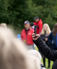 A hand filming with a smartphone - A Person Capturing a Video of a Cultural Event on Their Phone 