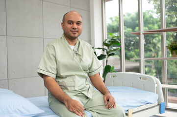 Fototapeta premium Confident patient sits beside hospital bed, posing in various poses, smiling warmly in gown, showing strength and positivity during recovery in bright and peaceful ward.