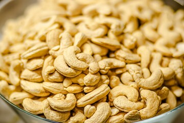 Close-up of a bowl filled with raw cashew nuts, showcasing their unique shapes and textures, emphasizing natural ingredients for healthy snacking and culinary uses