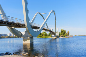 Naklejka premium Wavy Bridge Over the Dnieper River in Kyiv Offering Scenic Views of the Landscape