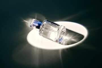 A bottle of perfume in the spotlight. White shades.