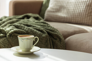 Cozy Autumn Scene with Green Cup of Coffee and Sofa Decor