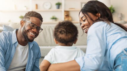 Obraz premium Family Bonding. Happy Millennial Parents Playing With Baby Toddler Together, Spending Time With Little Son At Home, Sitting On Floor Carpet. Child Care, Cute Parenthood Moments, Parenting Happiness