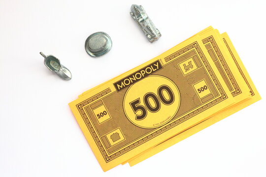 Monopoly money game concept. 500 cash banknote with metal tokens shoe, hat and car. Above angle photo.