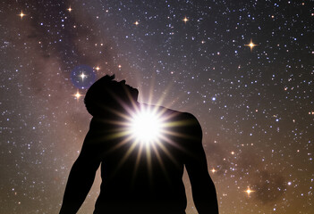A silhouette of a person looking up at a starry night sky, with a bright light radiating from their chest. It's a scene of wonder and awe, symbolizing introspection and connection to the universe.