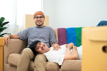 Obraz premium LGBTQIA2S+ couple lie on each other's laps, smiling as they build a new life together, two hearts, one new home, happy moving day, sharing warm moments in our new home, full of love and understanding.