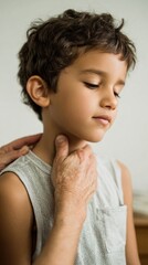 Young boy with curly hair wearing a breathable sleeveless t-shirt is being gently touched on the neck by an adult, conveying a moment of care and tenderness in a soft indoor setting