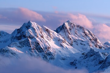 sunrise over snowy mountain peaks with soft clouds
