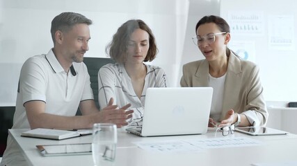 Business professionals reviewing marketing analytics on laptops, working together strategically in contemporary workplace with minimalist interior design and collaborative atmosphere - Powered by Adobe