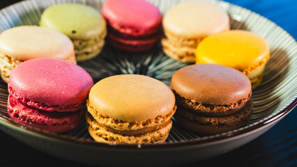 A beautiful assortment of vibrant and colorful French macarons, elegantly presented on a white plate. Perfect for dessert tables, pastry shop promotions, and food blog imagery.