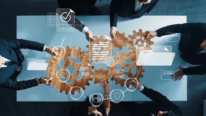 A diverse group of professionals collaborates around a table, engaging in strategic discussions with digital gear icons symbolizing innovation and teamwork in a modern office. Raster