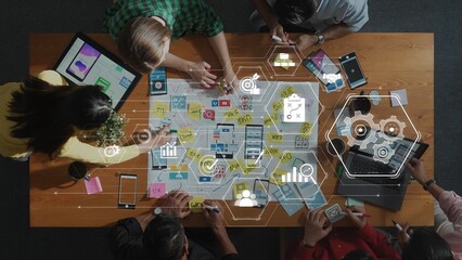 A dynamic aerial view of a collaborative brainstorming session in a modern office, showcasing digital tools and creative strategies for effective project planning among diverse team members. Raster