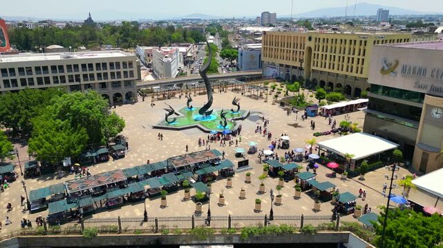 A drone advancing over the streets and flying above the Quetzalcoatl Fountain in Plaza Tapatia, Guadalajara, Mexico