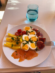Healthy Breakfast with Salmon, Eggs, Tomatoes, Bell Pepper and Figs on White Wooden Table