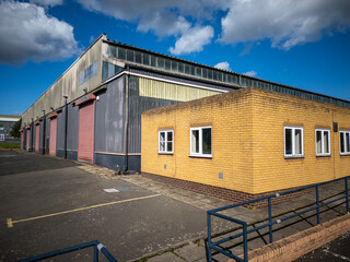 Drone aerial panorama of large logistics warehouse with high curved roof, loading docks and...