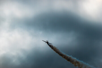 An aerobatic pilot in an aerobatic propeller plane shows off his skills in the sky