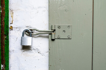 Padlock hanging on wooden door latch symbol of security and protection