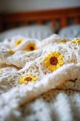 A delicate crocheted blanket, adorned with cheerful yellow sunflowers, lies draped over a bed.