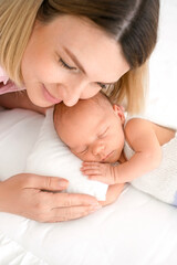 A mother gently hugs a sleeping newborn baby. World Mothers' Day.