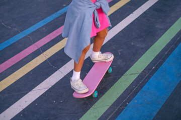 Close-up of a child riding a skateboard. Striped bright surface for skateboarding in a skate park