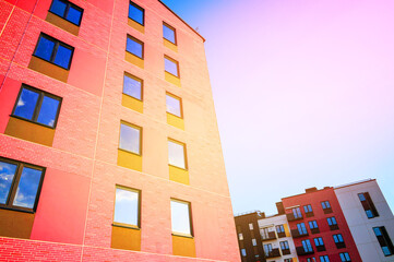 Brightly Colored Modern Buildings Under Clear Sky During Day Showcasing Urban Architecture Design. Modern facade building close-up. Two modern residential buildings feature bright colors.