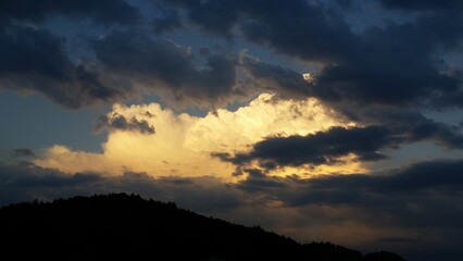 Dramatic Evening Cloud Formations with Bright White Sunlit Clouds Surrounded by Dark Black Clouds